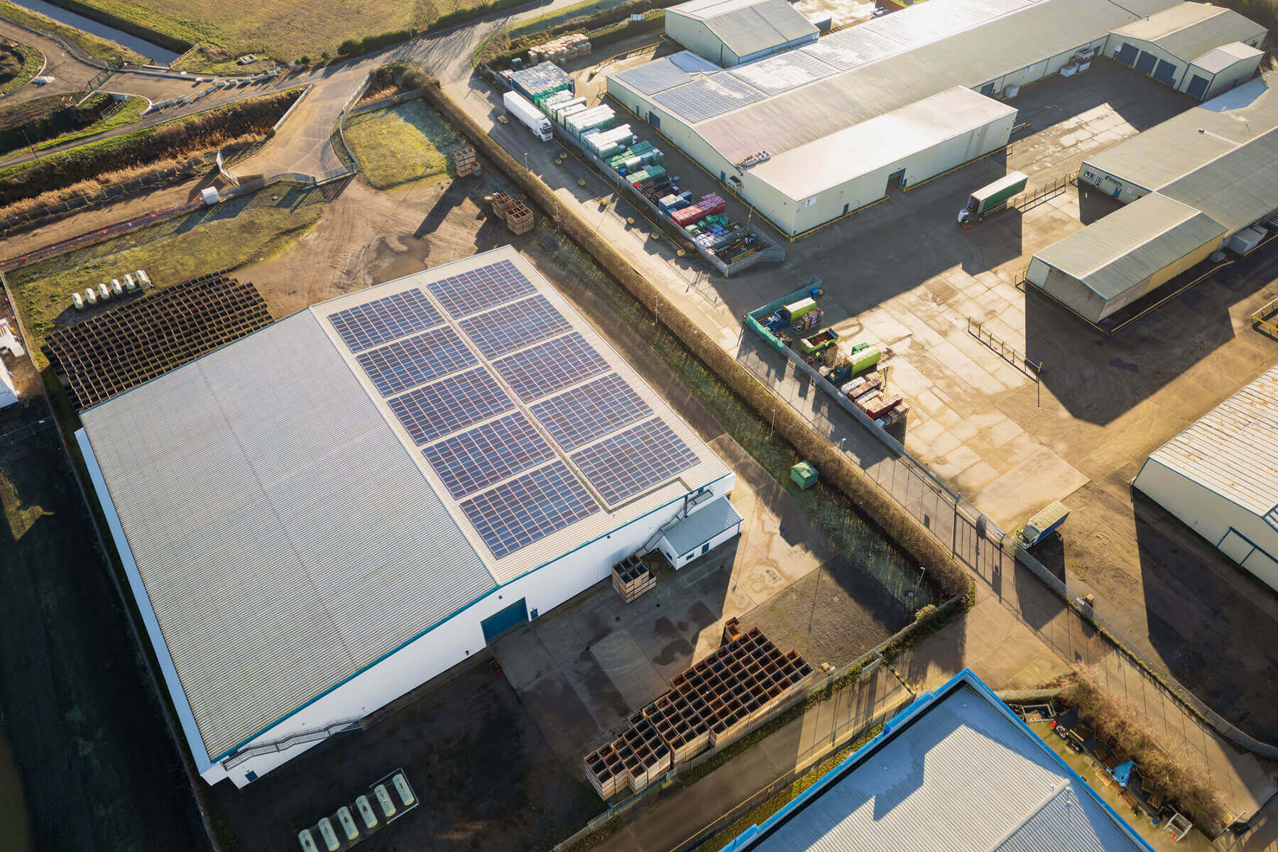 Aerial view of a commercial warehouse rooftop solar panel array