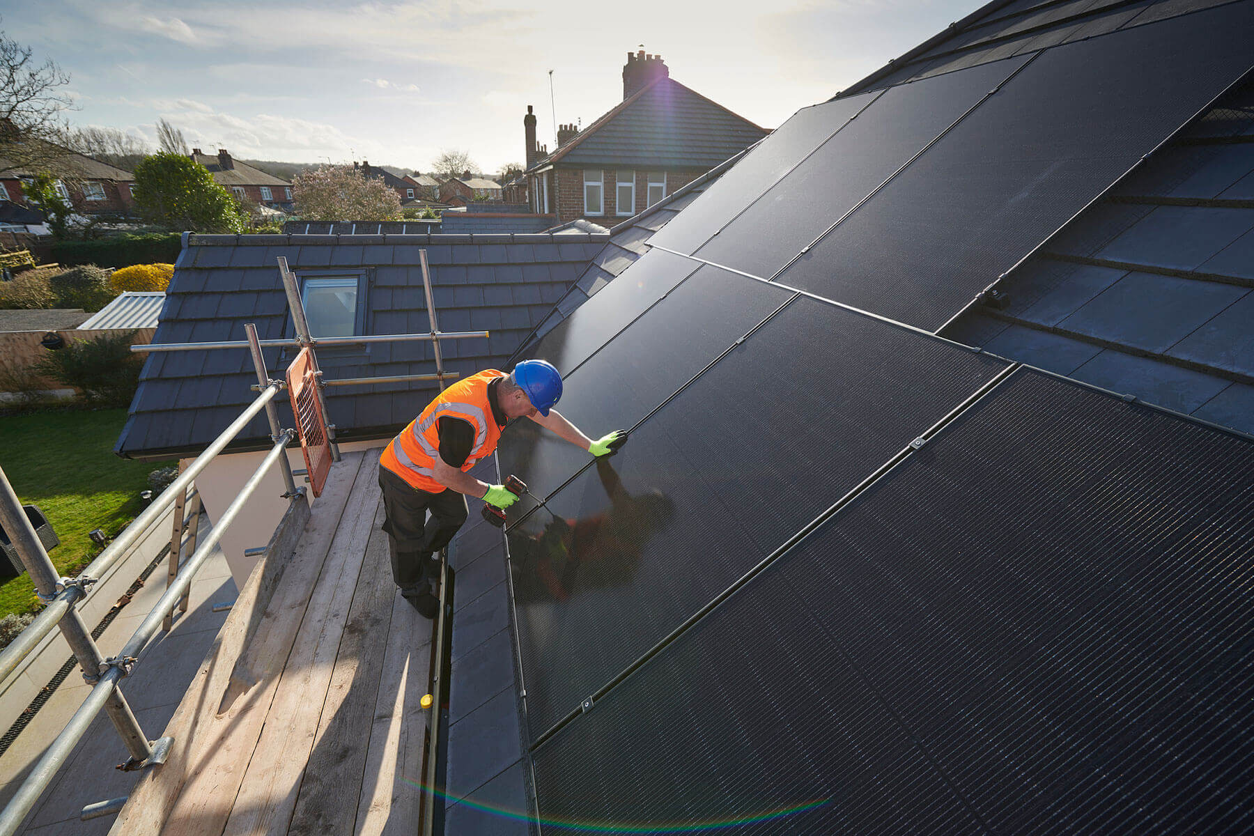 MCS-certified engineer installing black solar panels on a UK home roof